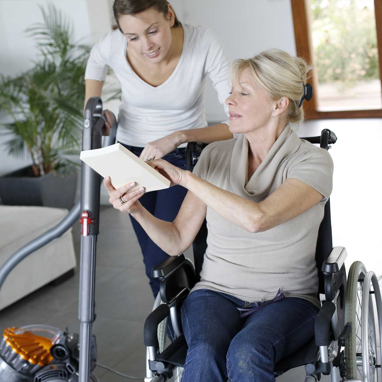Private-duty home aide in Queens helping a senior woman in a wheelchair with daily tasks, delivering in-home support that promotes independence and dignity.
